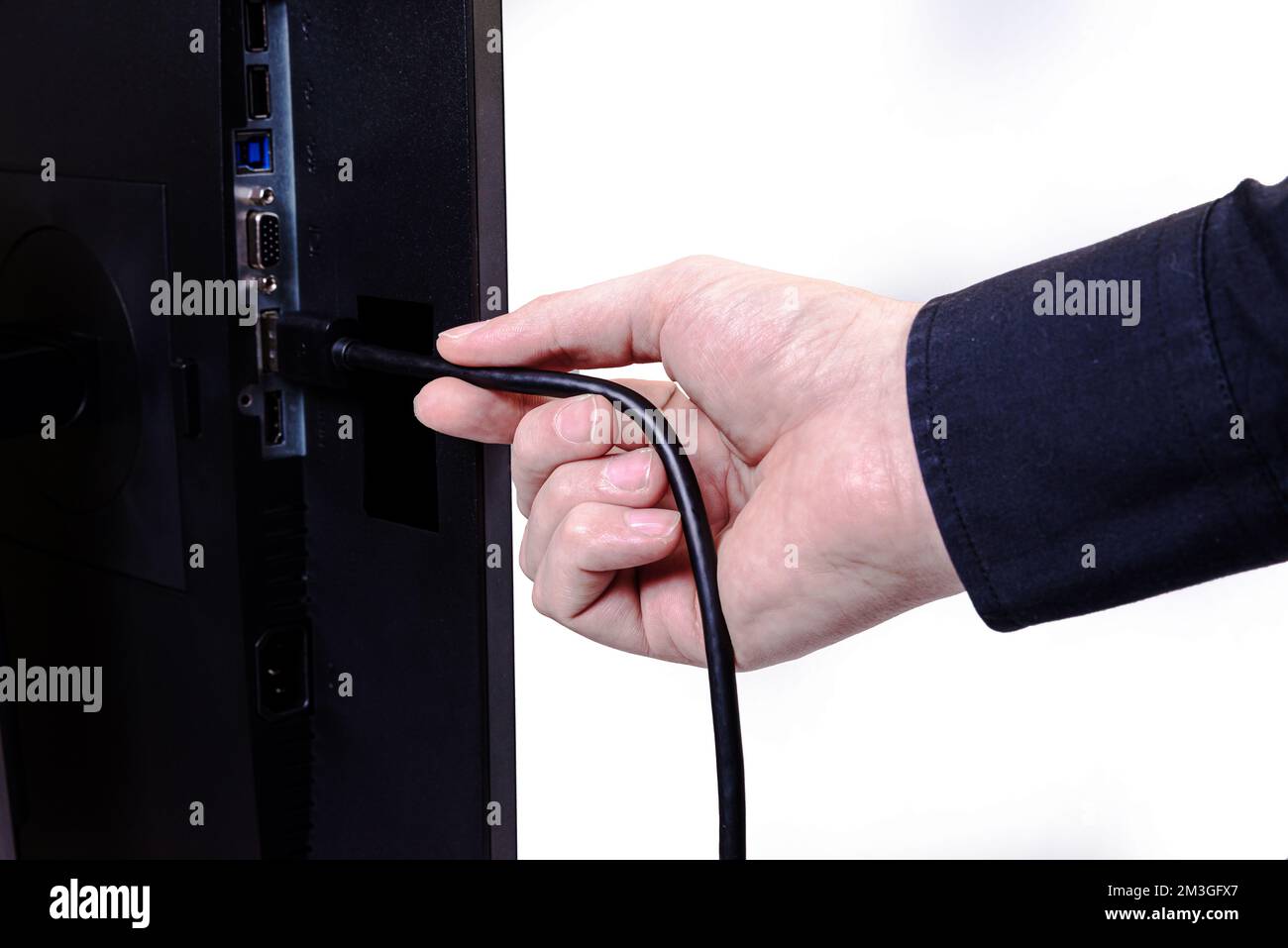 L'ingénieur INFORMATIQUE Man Hand insère le câble dans le moniteur. Homme à la main pour connecter le câble DVI du moniteur à l'ordinateur. VGA DVI DisplayPort et câble d'alimentation. cl Banque D'Images