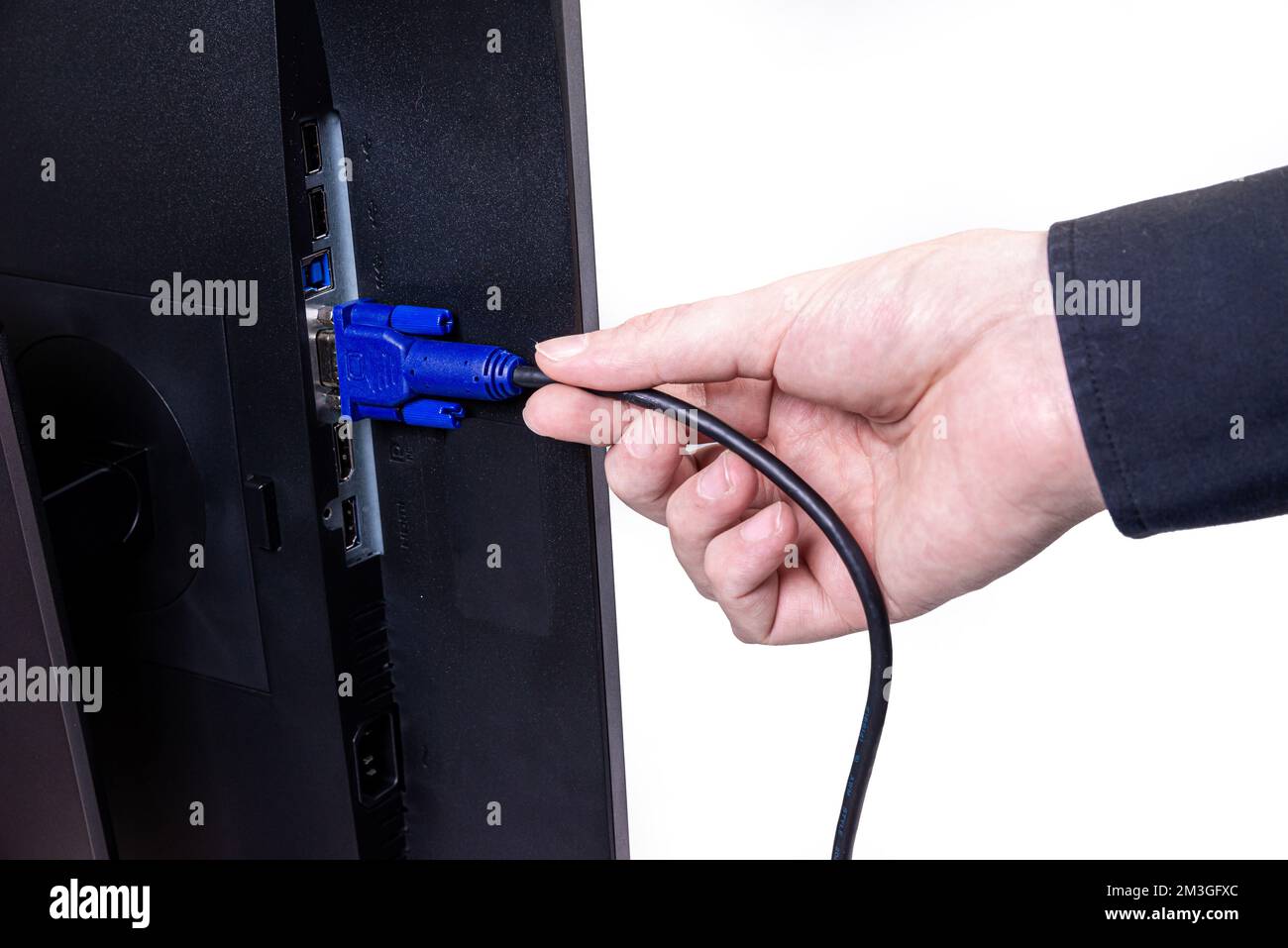 L'ingénieur INFORMATIQUE Man Hand insère le câble dans le moniteur. Homme à la main pour connecter le câble DVI du moniteur à l'ordinateur. VGA DVI DisplayPort et câble d'alimentation. cl Banque D'Images