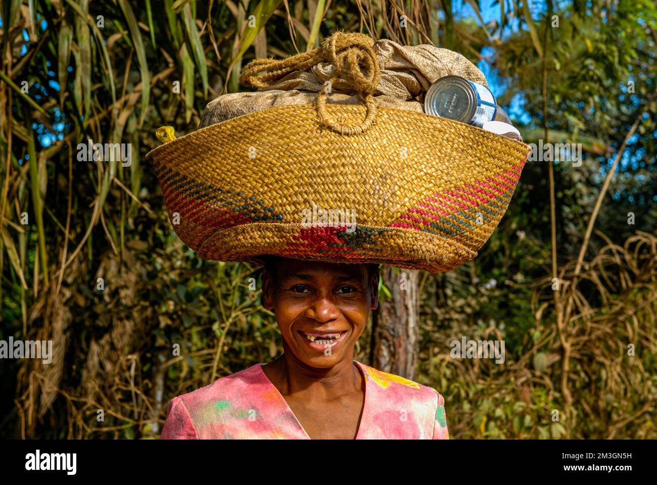 Femme portant un sac sur sa tête, Manakara sur la côte est de Madagascar Banque D'Images