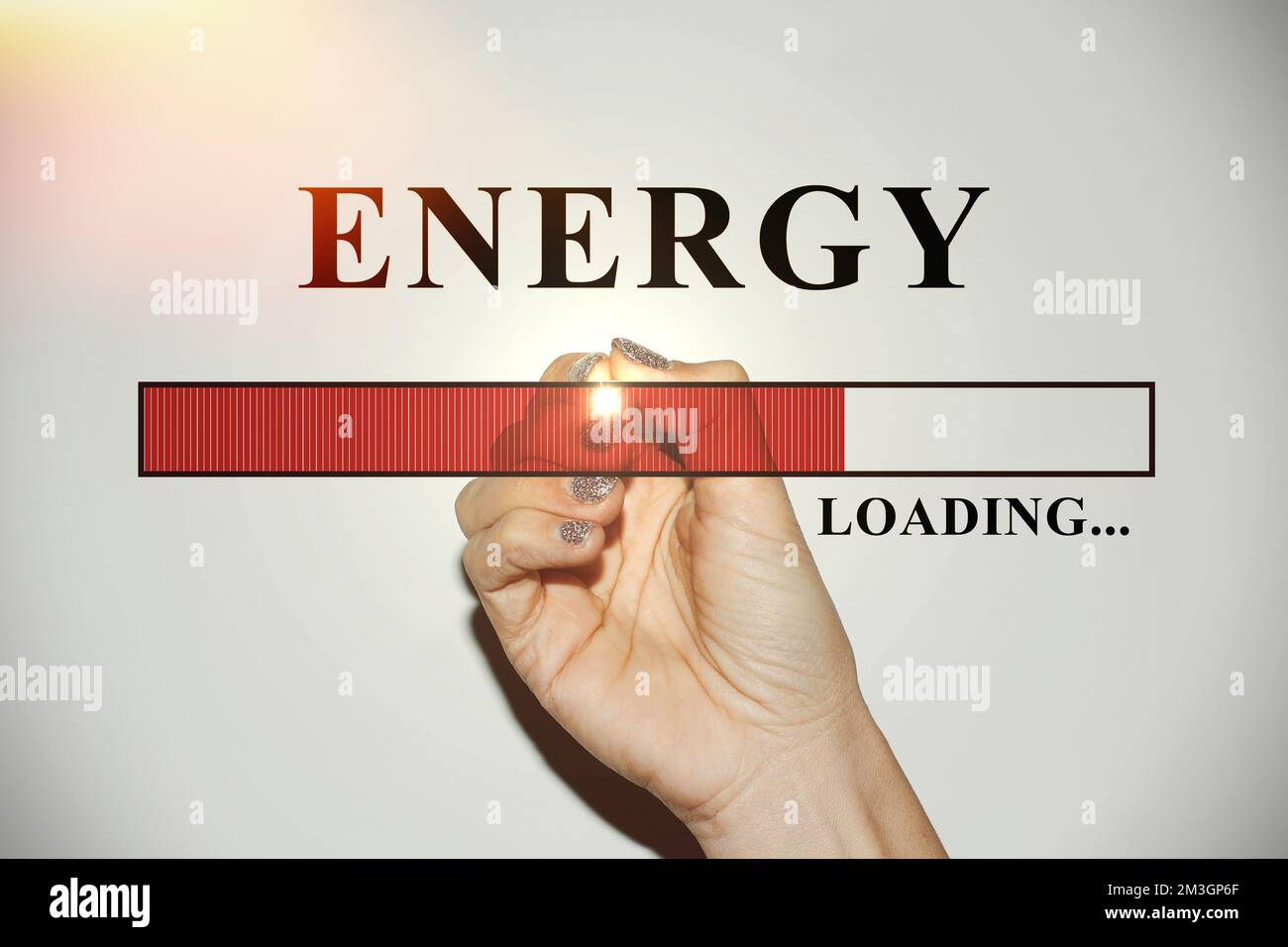 Main de femme avec clous scintillants montrant la barre de chargement avec le texte “énergie” Banque D'Images