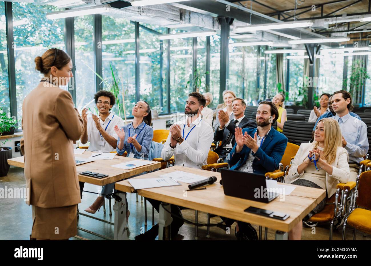 Image cinématographique d'une conférence. Les gens d'affaires assis dans une pièce à l'écoute de l'entraîneur de motivation. Représentation d'une croissance de soi et impro Banque D'Images