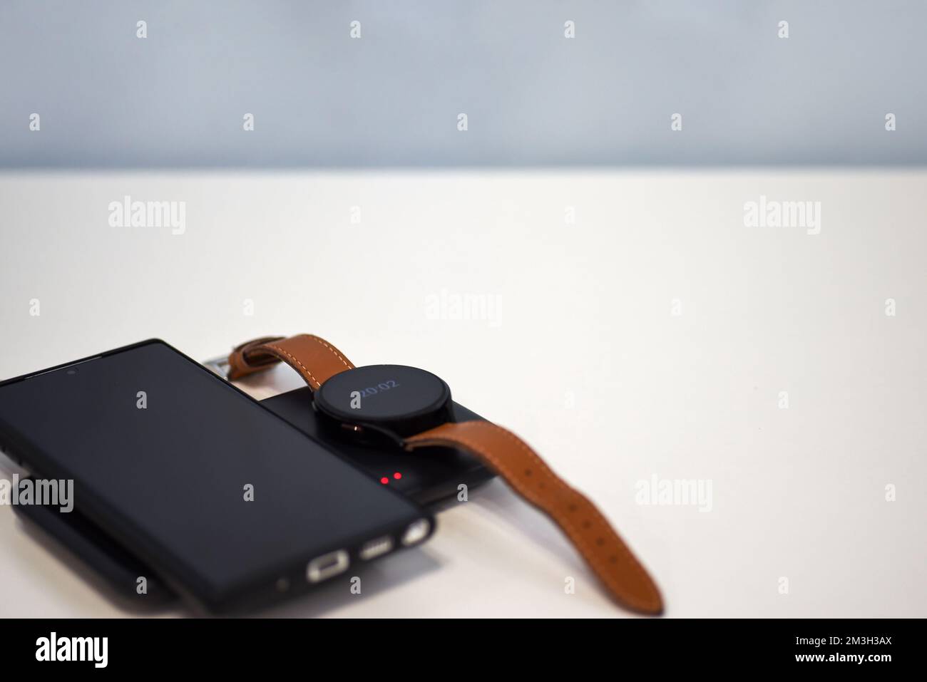 Smartphone et regardez le chargement sur le chargeur sans fil. Banque D'Images