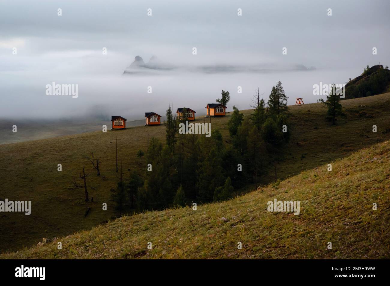 Petites maisons sur le matin brumeux entouré d'arbres sur la crête de la montagne. Petites huttes sur la crête de la colline par un jour brumeux. Banque D'Images