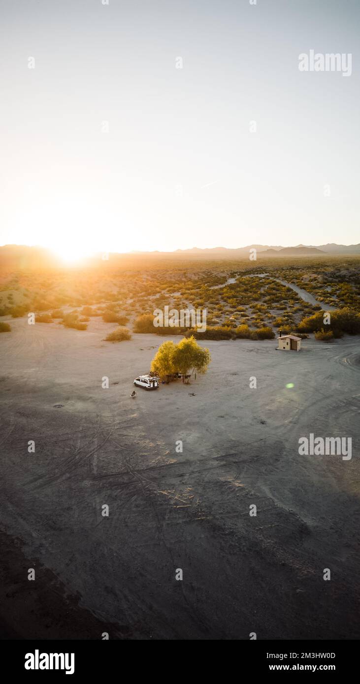 Vue aérienne un drone de la vie de van vivant et travaillant dans la région éloignée du désert des états-unis du nevada avec le soleil se coucher à distance avec des teintes chaudes d'orange et de soupir Banque D'Images