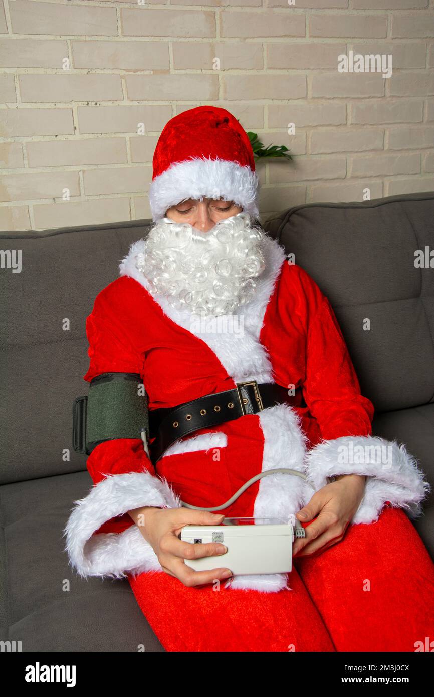 Le Père Noël est malade et ne se sent pas bien. Le père Noël mesure la pression artérielle Photo