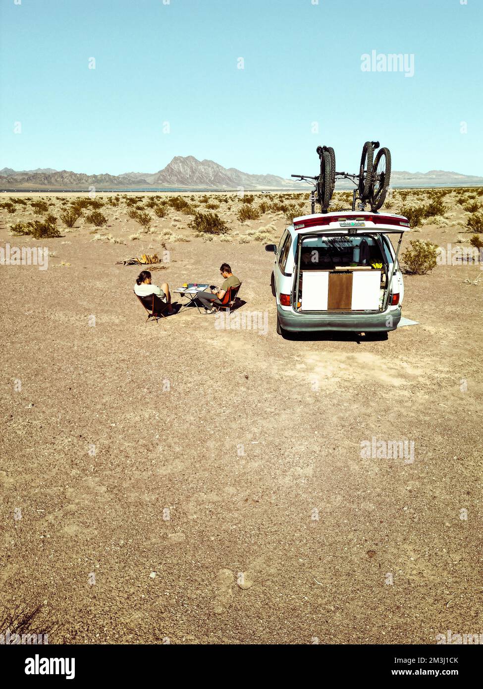 Homme et femme travaillent à distance depuis leur véhicule numérique nomade de camping van LIFE en planifiant le contenu et la stratégie dans la nature sauvage d'un lac sec être Banque D'Images