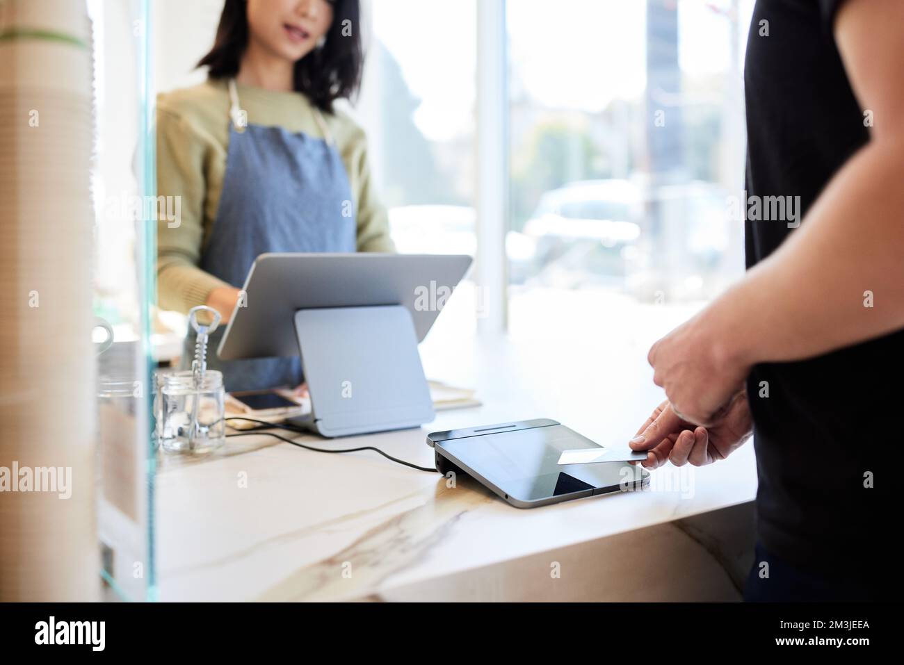 Client homme mature payant par carte de crédit au comptoir de caisse Banque D'Images