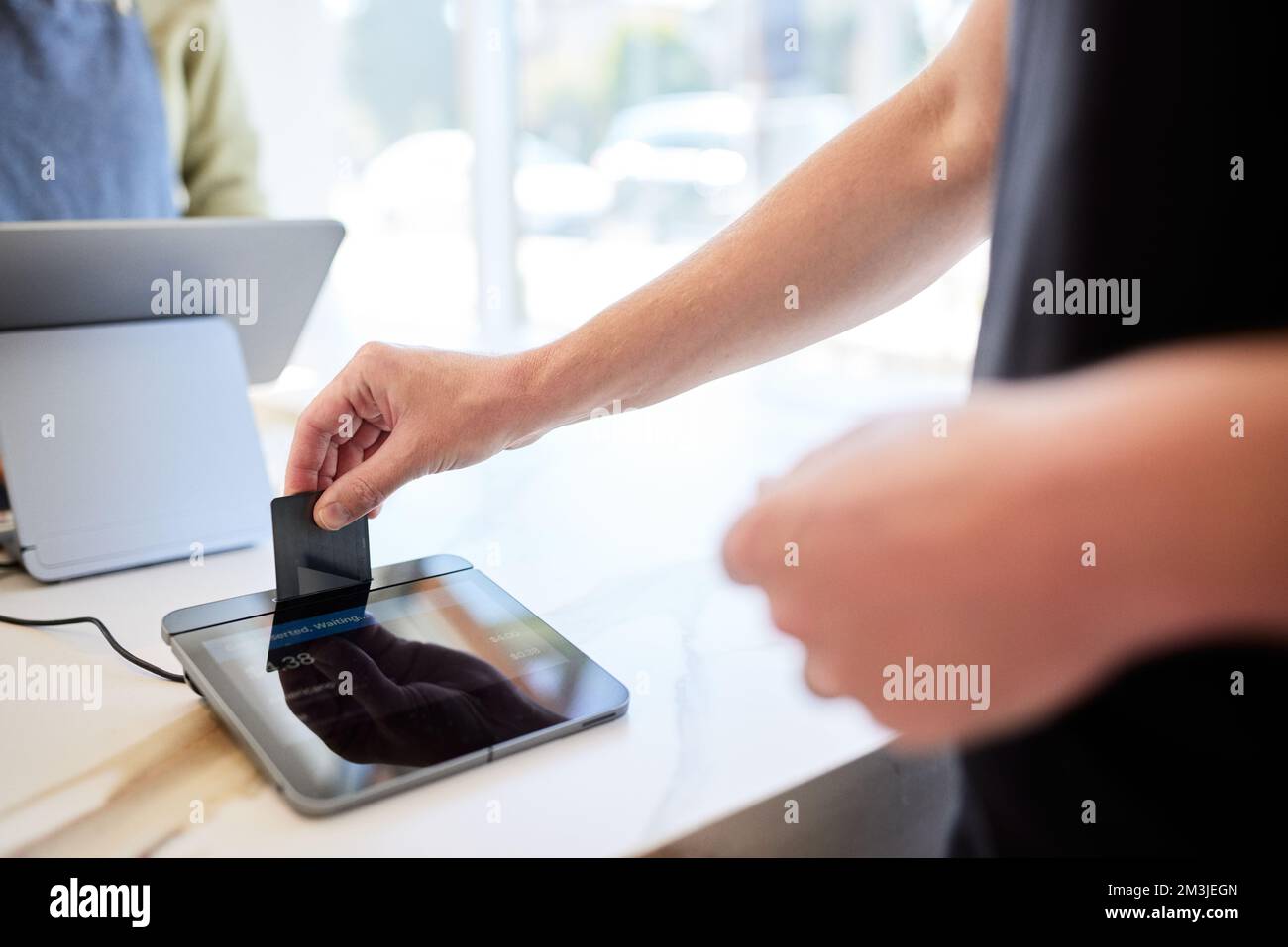 Un client de sexe masculin insère une carte de crédit dans le système POS du café Banque D'Images