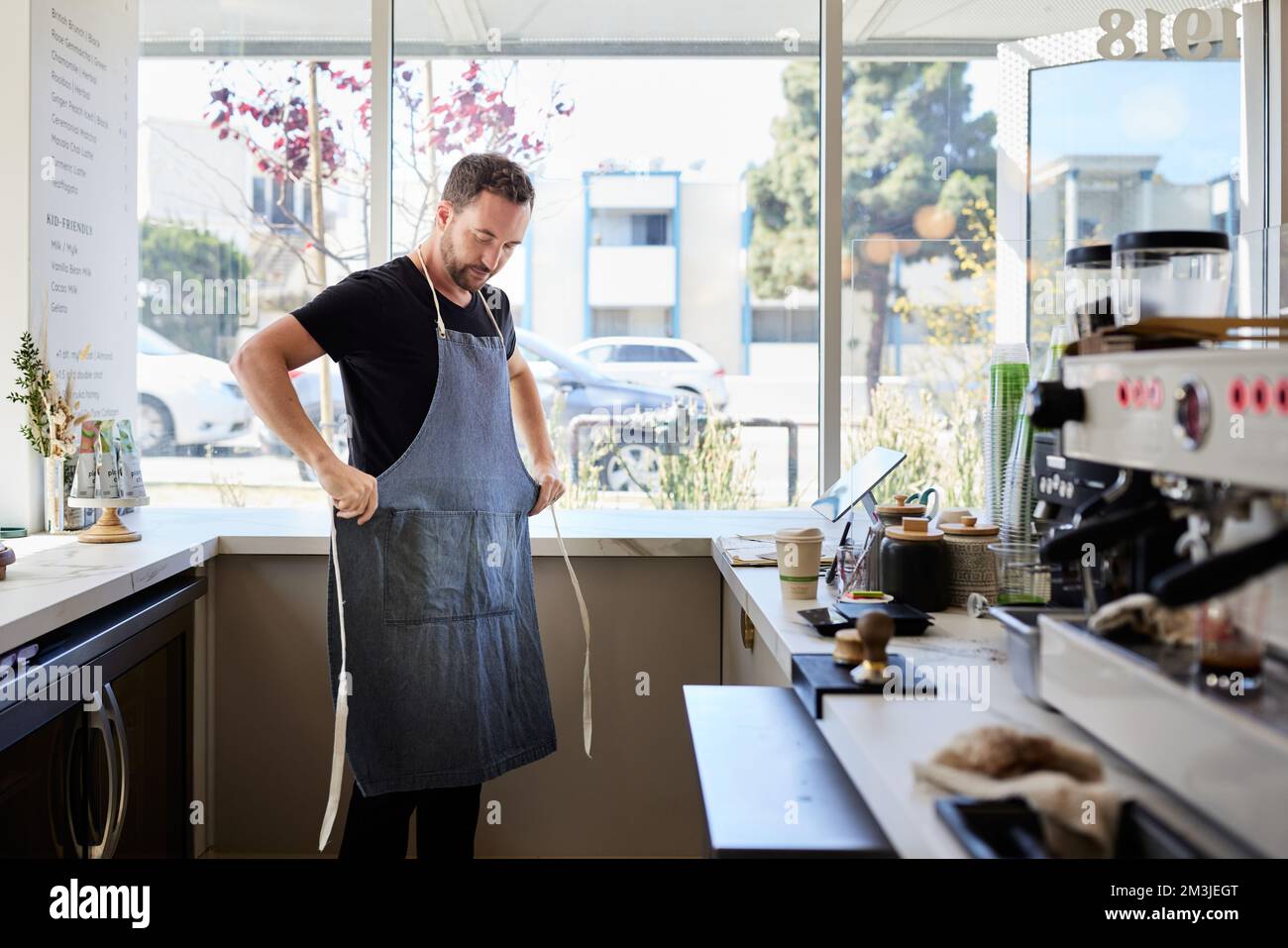 Homme entrepreneur portant un tablier dans la cuisine au café Banque D'Images