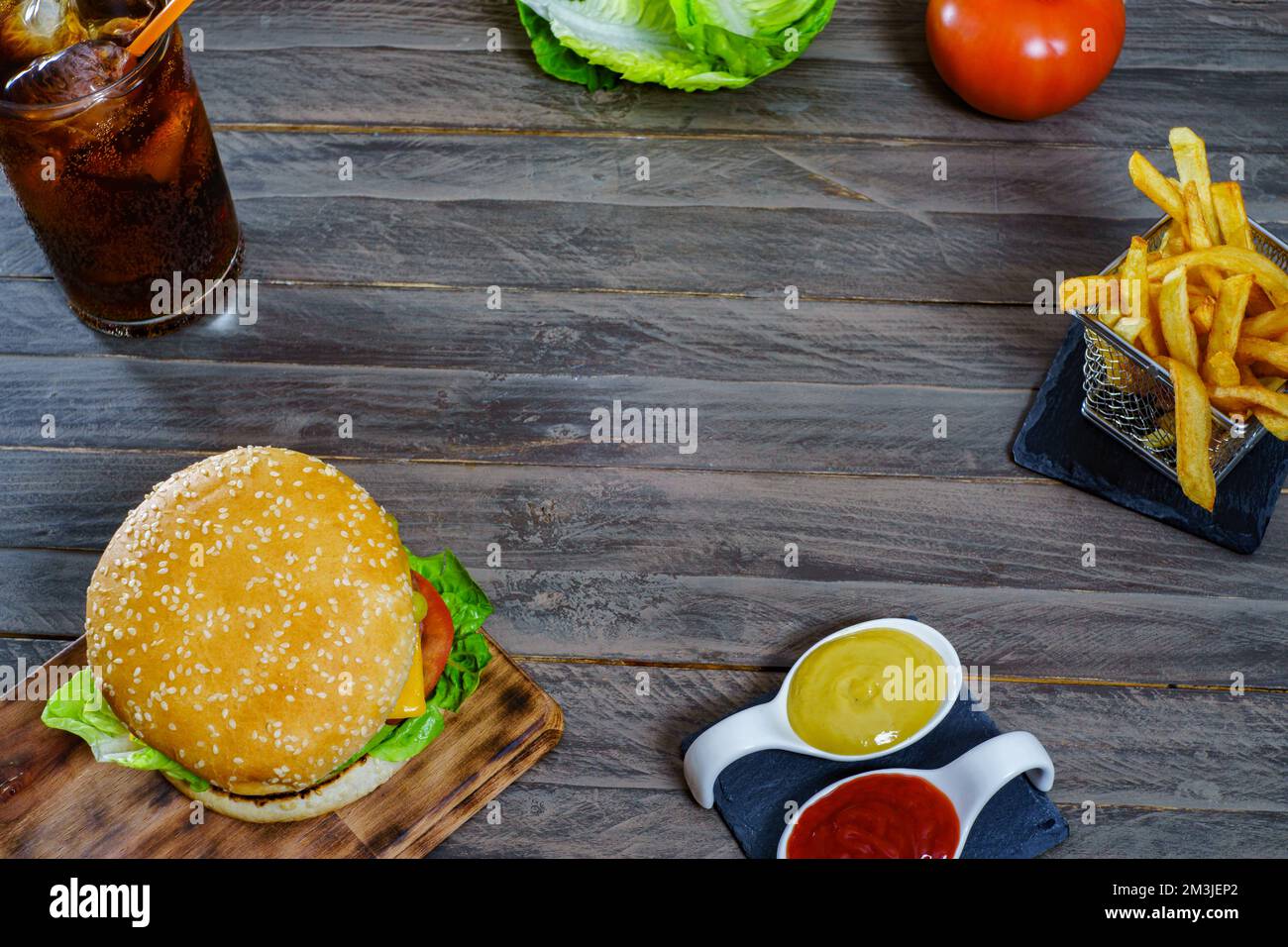 hamburger complet avec deux viandes, sauces, frites et soda au cola. Banque D'Images