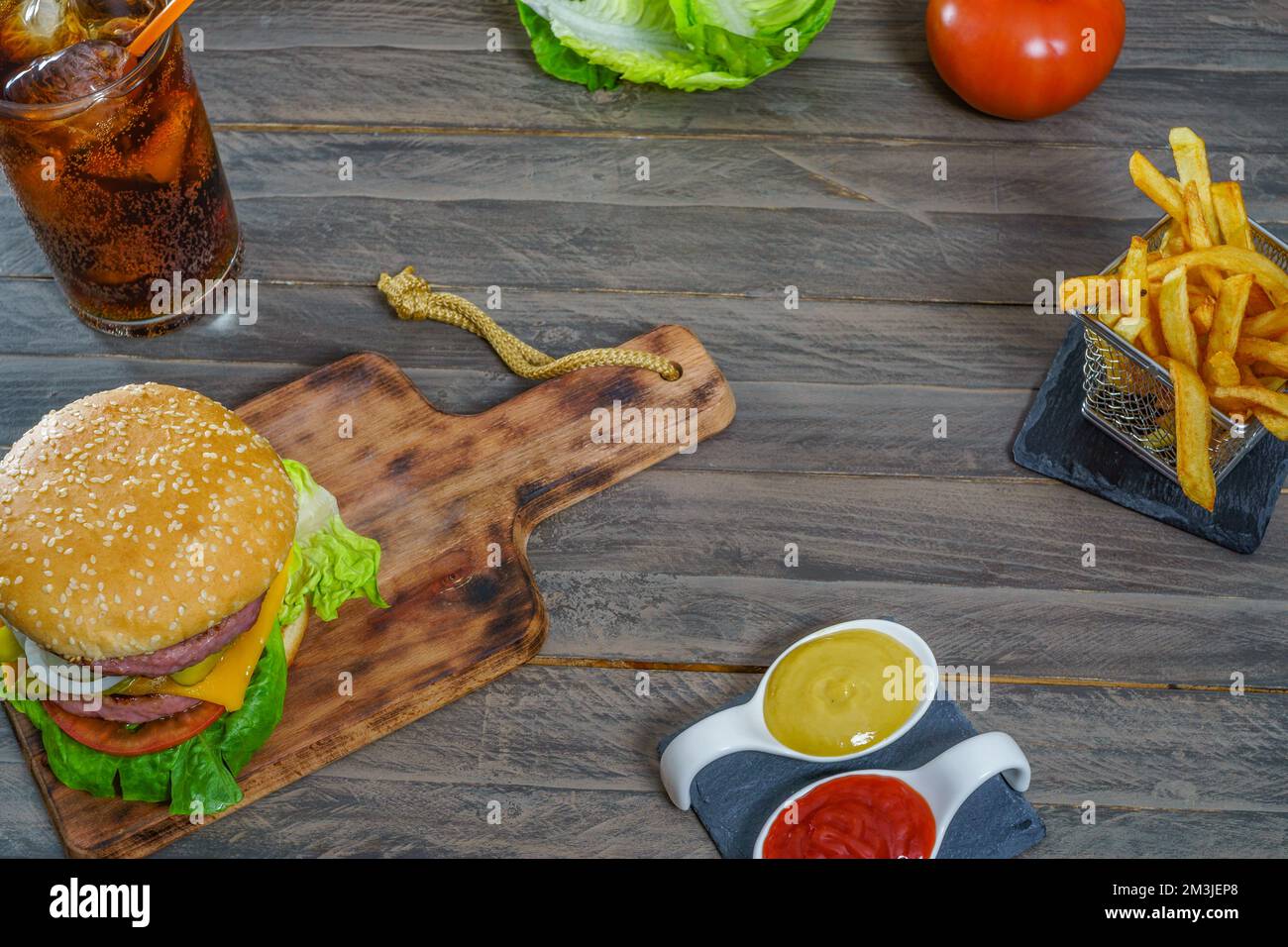 hamburger complet avec deux viandes, sauces, frites et soda au cola. Banque D'Images