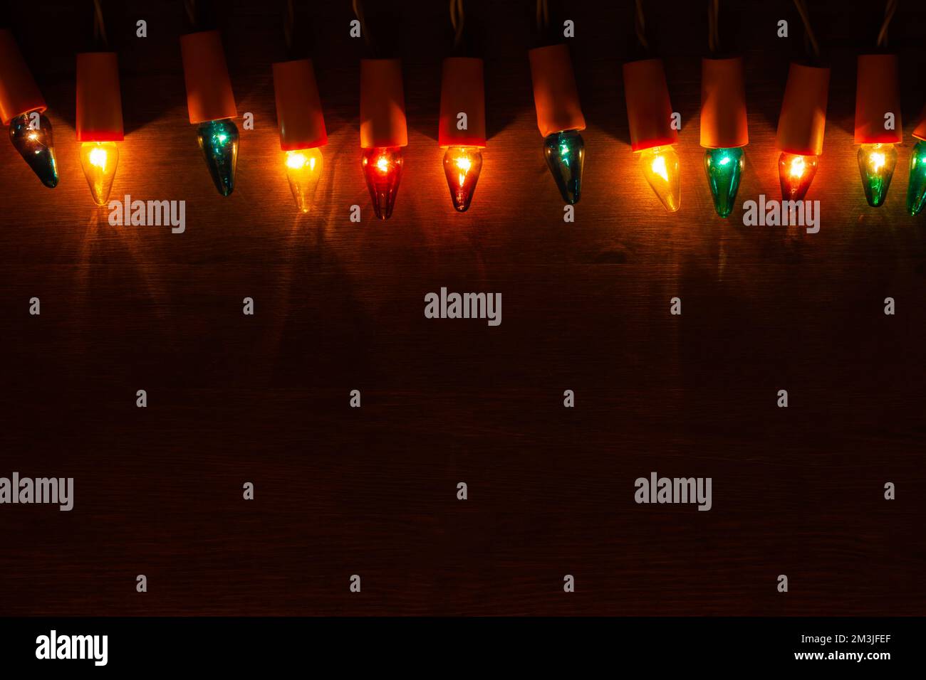 Lumières de Noël. Ampoules rétro de différentes couleurs sur fond en bois foncé avec espace de copie Banque D'Images