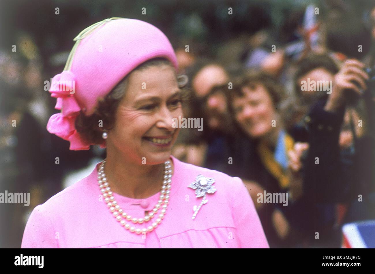 La reine Elizabeth II, une vision en rose, est accueillie par une foule lors d'une promenade royale à Londres pour le Jubilé d'argent, 1977. Date: 1977 Banque D'Images