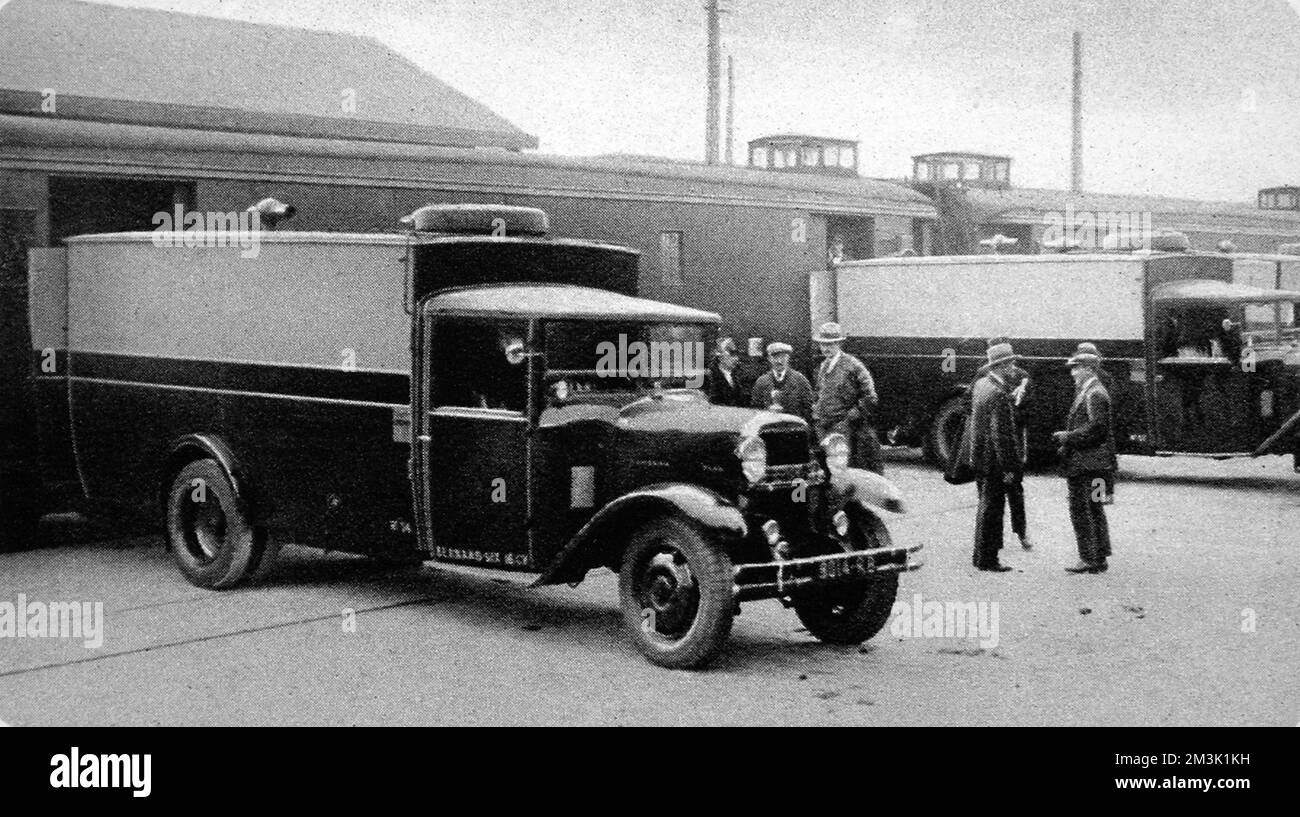 Photographie montrant le transfert d'un lingots d'un train qui venait d'arriver du Havre, à la gare de Batignolles à Paris, dans des camions à moteur pour le transport à la Banque. Date: 1931 Banque D'Images