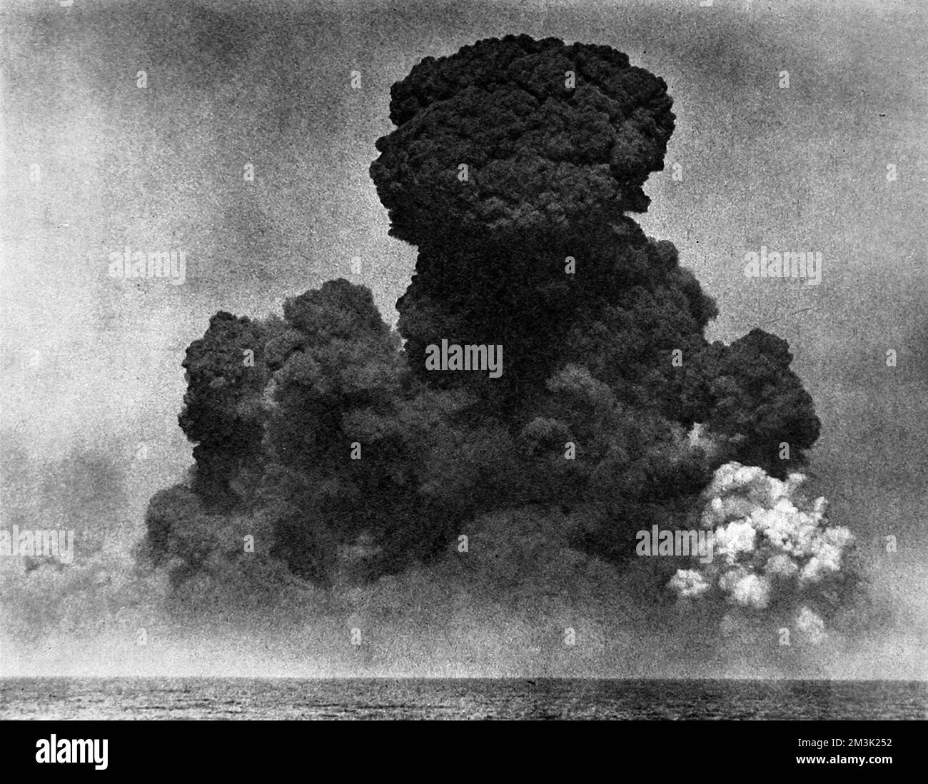 Photographie montrant la destruction de l'ancienne base navale d'Heligoland, en Allemagne, le 18th avril 1947. Heligoland avait été un bastion pour les forces militaires allemandes pendant les deux guerres mondiales et a été détruit par les forces armées britanniques, en utilisant 6700 tonnes de haut explosif, dans le cadre de la reconstruction d'après-guerre de l'Allemagne. Le grand nuage de fumée montré dans cette photo était rouge avec du grès désintégré et s'est levé à une hauteur estimée de 10 000 pieds. Date: 1947 Banque D'Images