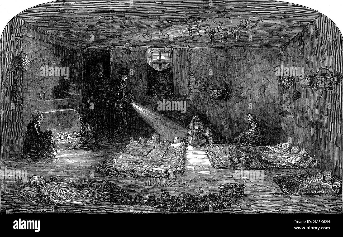 L'intérieur calmar d'une maison d'hébergement de Londres décrépite révélée par la torchlight. Les gens dorment sur le sol avec un minimum de linge de lit tandis qu'un homme illumine le visage d'une lampe torche. 22 octobre 1853 Banque D'Images