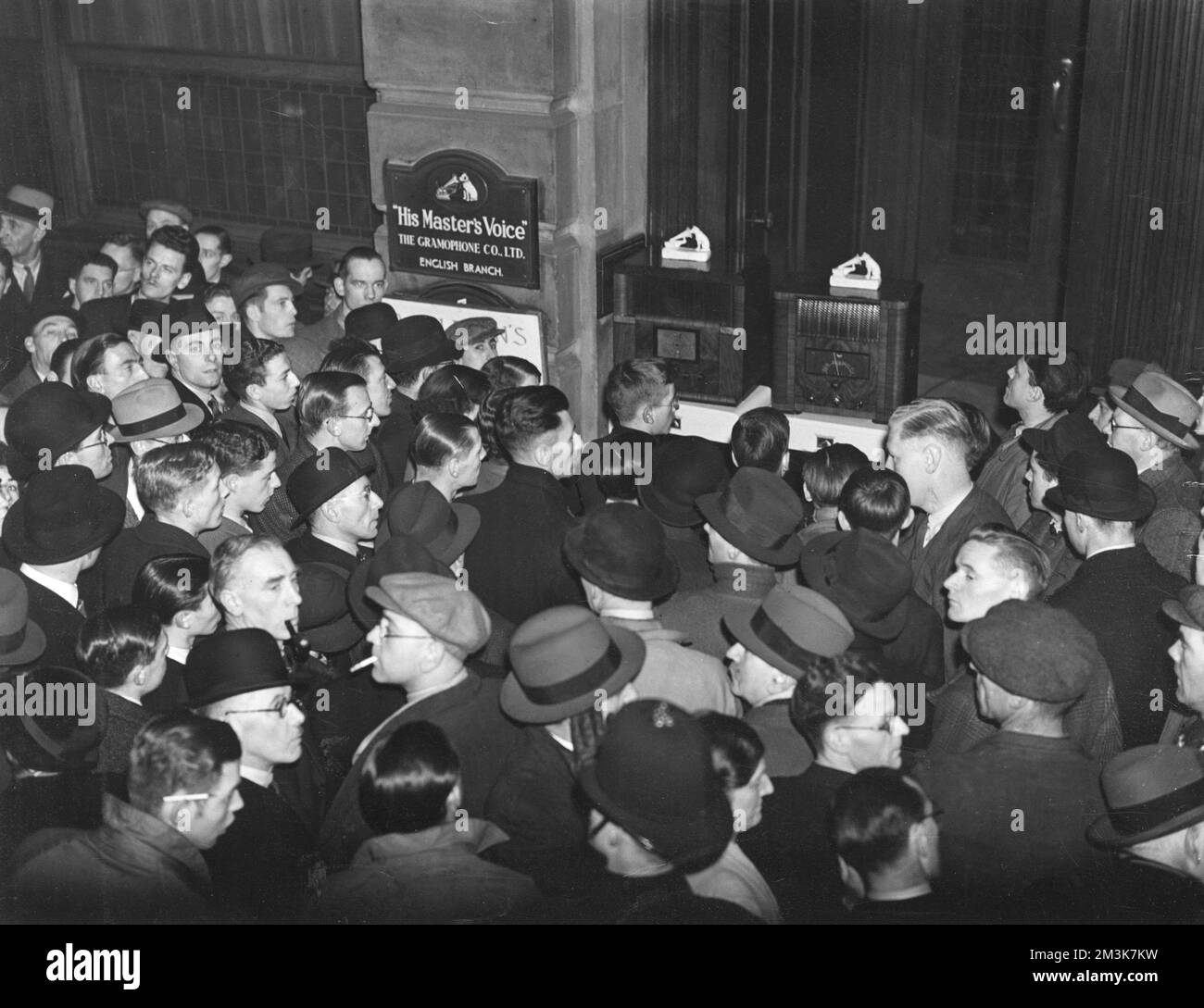 Des foules écoutent des radios installées par sa voix de maître à l'extérieur de leurs bureaux de Clerkenwell en décembre 1936 pour le discours abdication du roi Edward VIII. Date: 01/12/1936 Banque D'Images