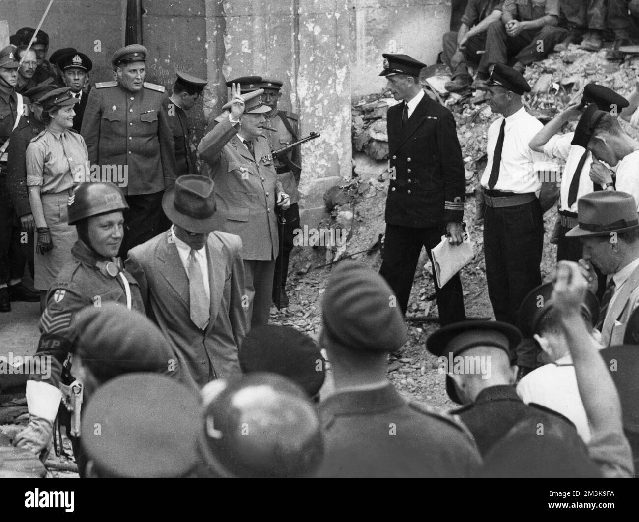 Sir Winston Leonard Spencer Churchill (1874-1965) politicien britannique et Premier ministre parmi les ruines de Berlin à la fin de la Seconde Guerre mondiale en saluant la victoire du V signe Banque D'Images