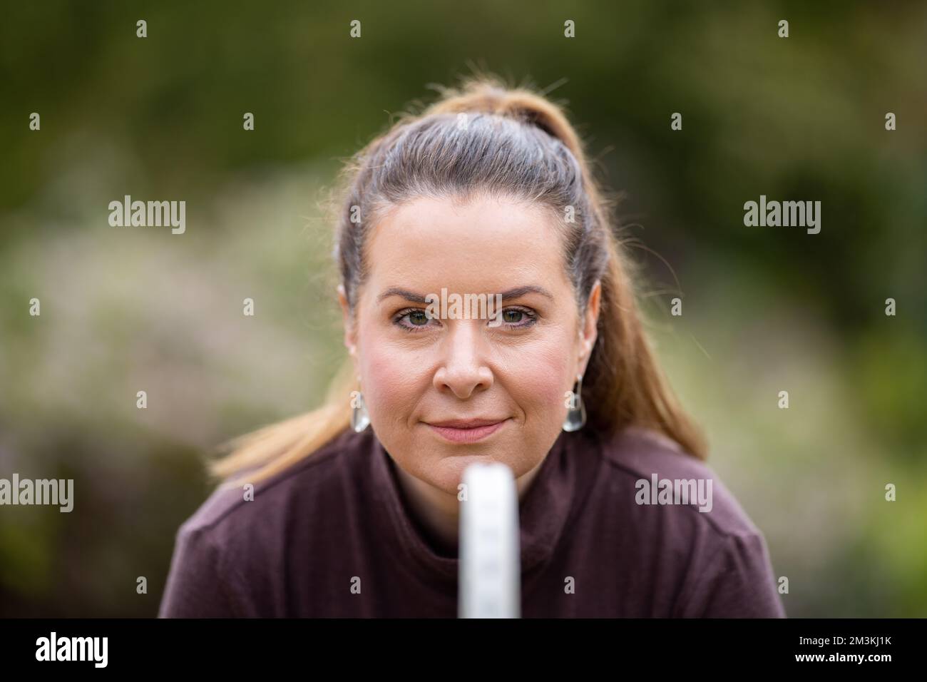 une joueuse de tennis pratiquant les mains avant et frappant des balles de tennis sur un terrain d'herbe en angleterre Banque D'Images