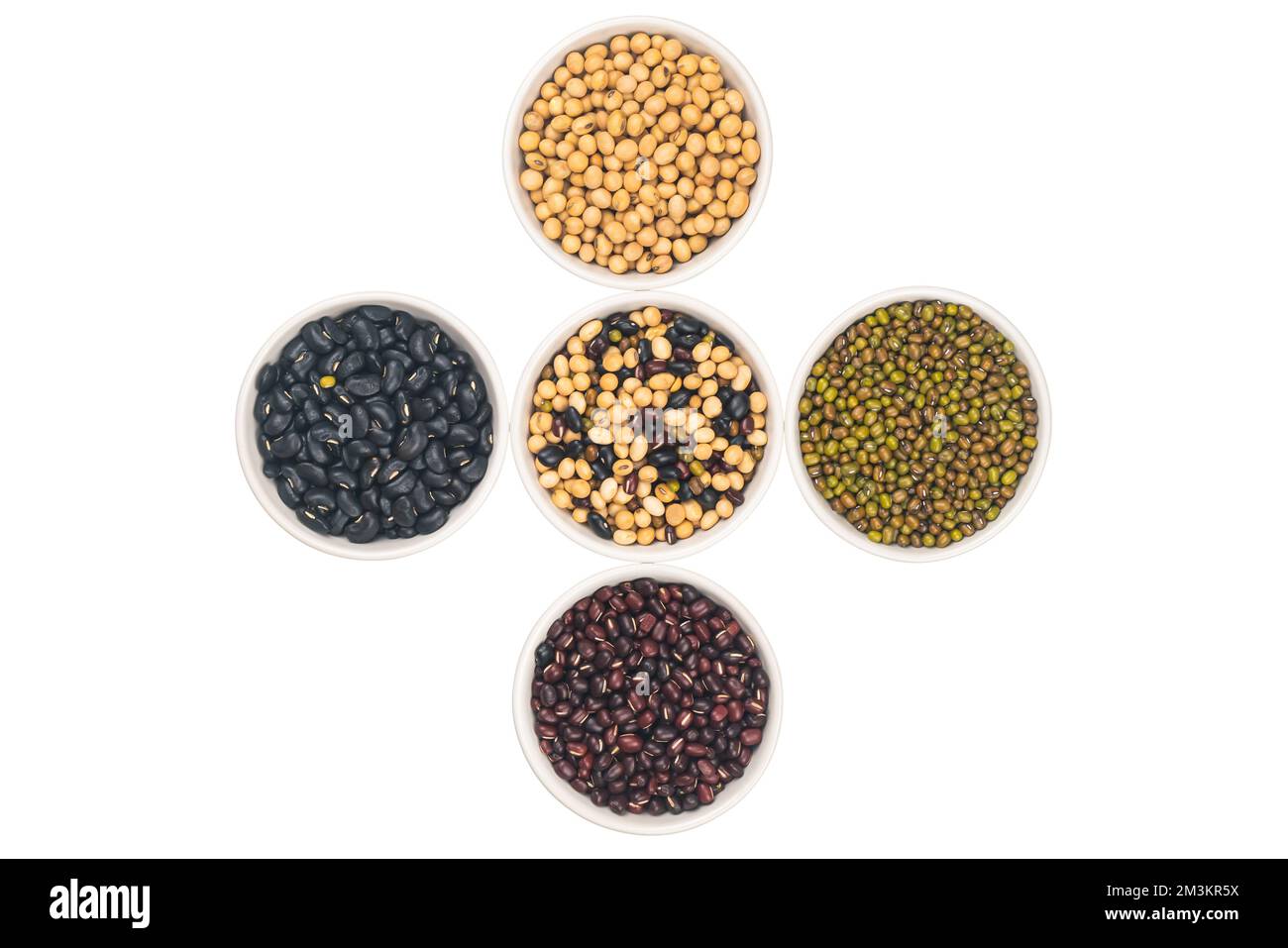 Vue de dessus de divers grains organiques secs dans un bol en céramique blanc isolé sur fond blanc avec passe-cheveux. Banque D'Images