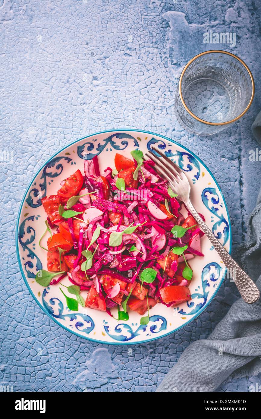 Salade d'hiver - salade de chou rouge mariné avec radis, tomates, oignons et froussettes d'hiver. Des aliments sains végétariens. Banque D'Images