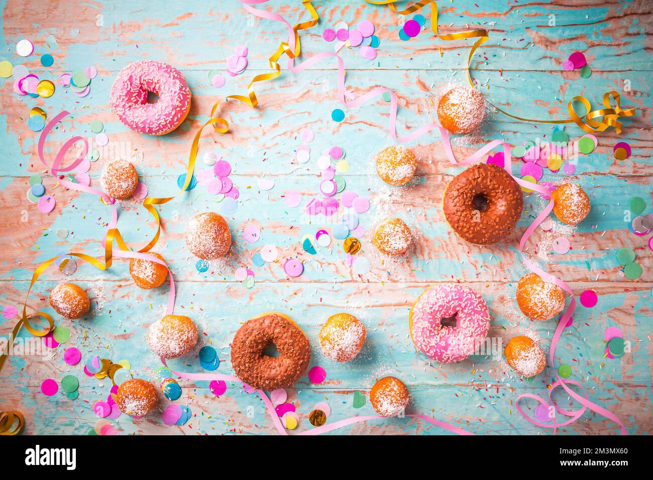 Berliner traditionnel pour le carnaval et la fête. Krapfen allemand ou beignets avec des banderoles et des confettis. Image de carnaval ou d'anniversaire colorée Banque D'Images