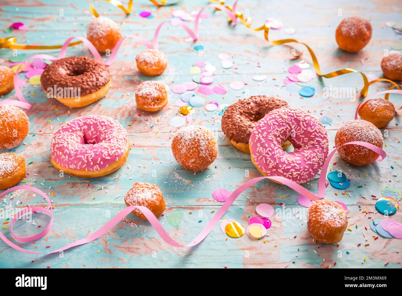 Berliner traditionnel pour le carnaval et la fête. Krapfen allemand ou beignets avec des banderoles et des confettis. Image de carnaval ou d'anniversaire colorée Banque D'Images