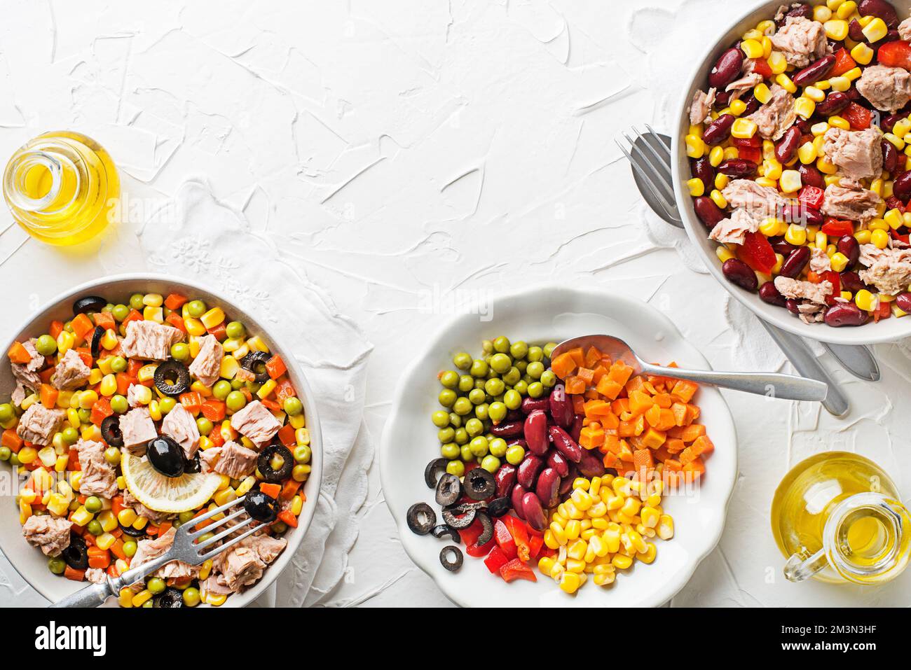 Salades de thon saines avec légumes mélangés en conserve sur fond de table blanc. Salade de maïs mexicaine. Banque D'Images