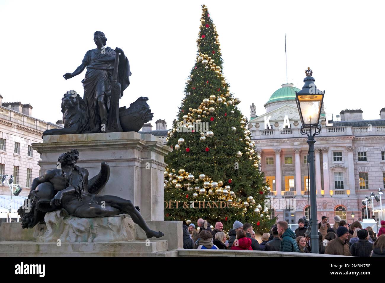 Décorations sur l'arbre de Noël, gaslamp et touristes les gens dehors à la patinoire d'hiver de Somerset House à Londres Angleterre Royaume-Uni décembre 2022 KATHY DEWITT Banque D'Images