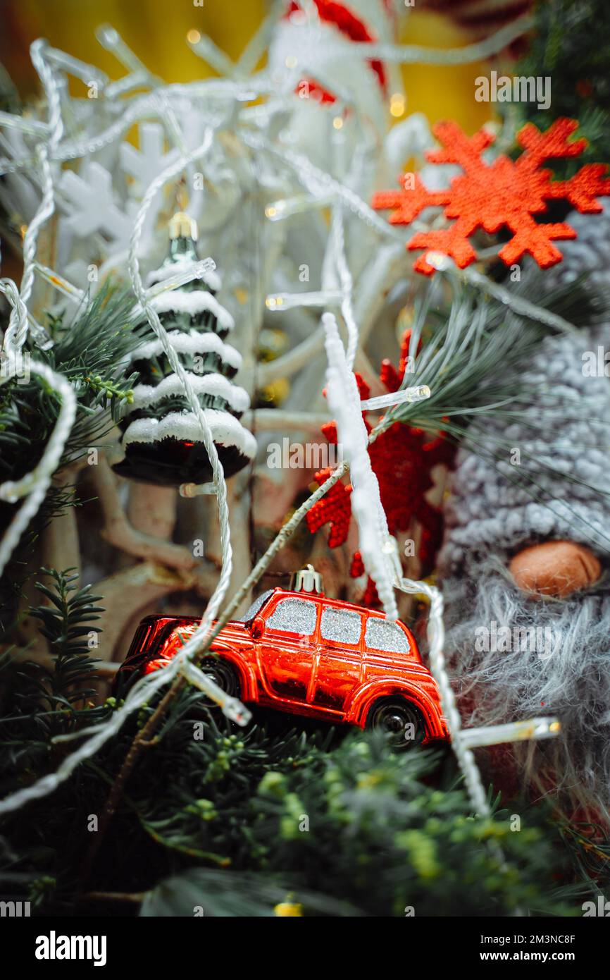 Voiture rouge, flocon de neige et sapin de Noël sur les décorations de pêches de pin. Décorations de rue dans le marché de Colmar en Alsace Banque D'Images