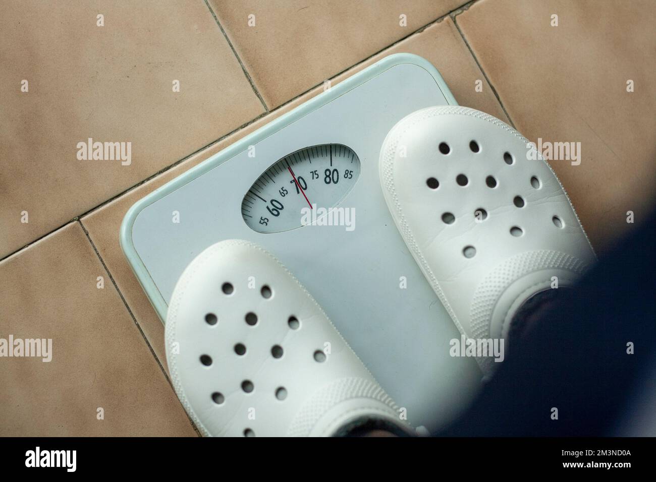 Échelle analogique où une personne est pesée et son poids peut être vu en kg Banque D'Images