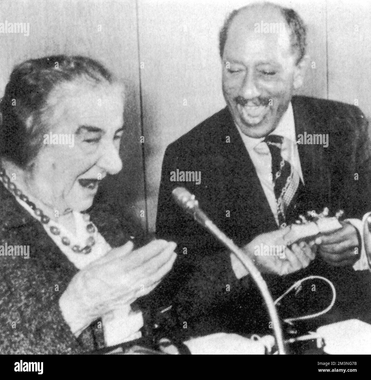 Golda Meir(1898-1976) présente au Président égyptien Anwar Sadat(1918-1981) un cadeau pour son nouveau petit-enfant. Sadate est devenu le premier dirigeant arabe à avoir mis les pieds en Israël au cours de ses 29 années d'existence lorsqu'il est arrivé à tel Aviv au début de sa visite de deux jours. Date : novembre 1977 Banque D'Images