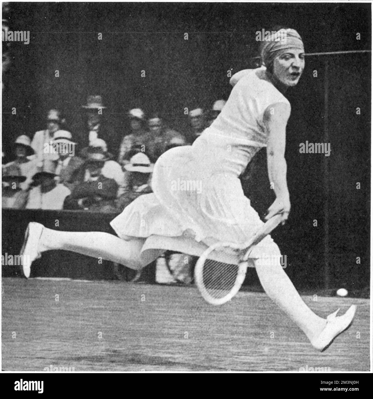 Suzanne Lenglen (1899 - 1938), joueuse française de tennis, gagnante de 81 titres de singles en 1920s. Photographié sur le terrain pour une balle et portant son bandeau caractéristique lors de la finale des dames de Wimbledon 1925 qu'elle a gagnée, battant Mlle Joan Fry. Date: 1925 Banque D'Images