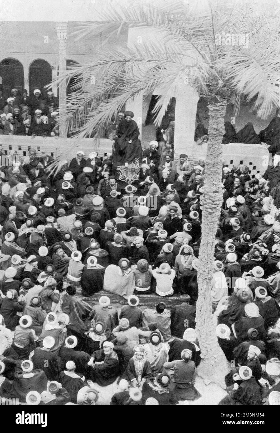 Un groupe de Perses écoute un discours prononcé par un représentant du Shah pour inculquer la loyauté à ses sujets. Date: 1909 Banque D'Images