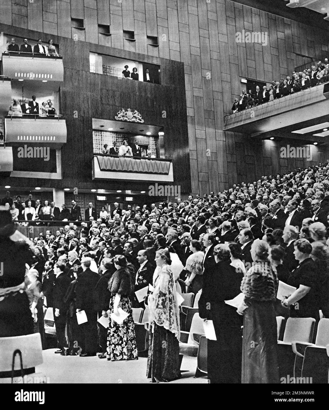 Scène à l'ouverture royale du nouveau Royal Festival Hall, sur la Rive-Sud, Londres, avec un auditorium complet, et des membres de la famille royale dans la boîte royale -- le roi George VI et la reine Elizabeth, la princesse Elizabeth et le duc d'Édimbourg, et la princesse Margaret. Après l'hymne national est venu un service de dévouement, avec un bref discours de l'archevêque de Canterbury, puis un concert inaugural avec la musique britannique convenablement patriotique. Date : 3 mai 1951 Banque D'Images