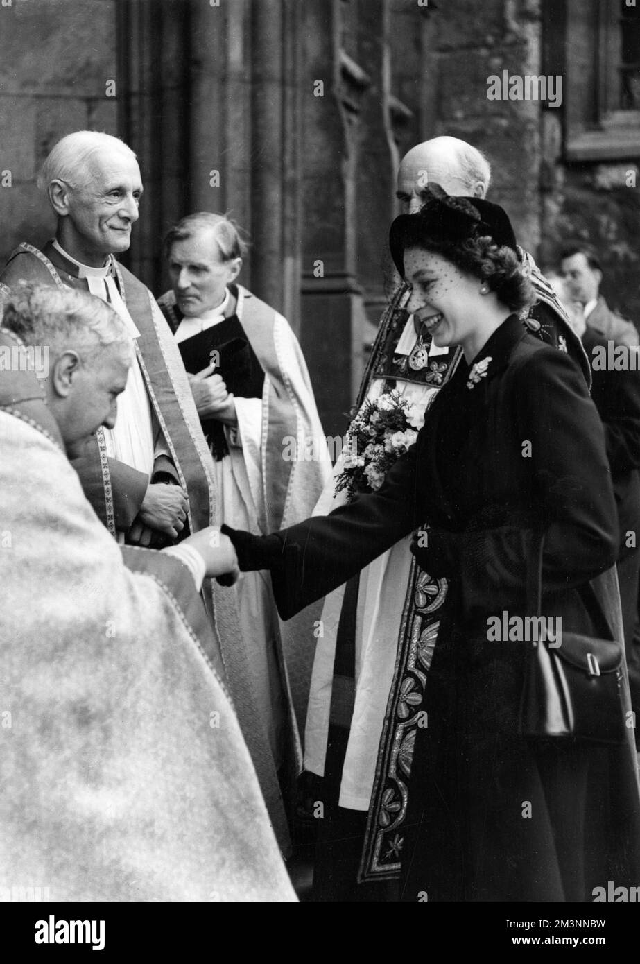 La reine Elizabeth II étant accueillie à son arrivée à l'abbaye de Westminster, lorsqu'elle a distribué l'argent du Royal Maundy. Dans l'année de cette photo, 1952 26 hommes et femmes âgés, une fois pour chaque année de l'âge du souverain, recevront la clôture d'argent, spécialement frappée à la monnaie royale dans des bourses en cuir. Les pièces portent encore l'impression de la tête du roi George VI Date : 10th avril 1952. Banque D'Images