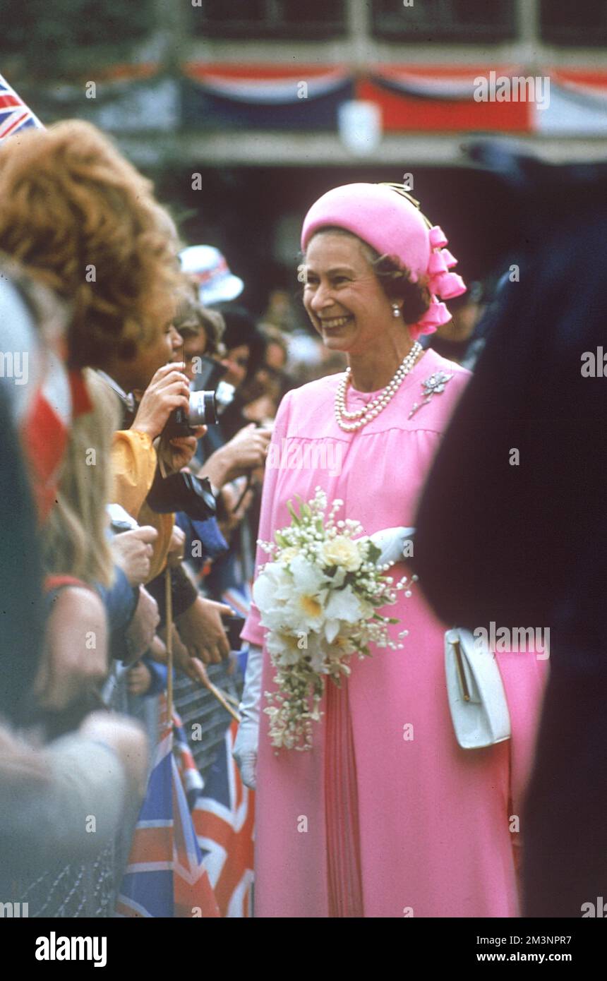 La reine Elizabeth II, une vision en sourires roses et de discuter avec des foules de bien-enthousiastes alors qu'elle va sur une promenade royale à Londres pour célébrer le Jubilé d'argent en 1977. Banque D'Images