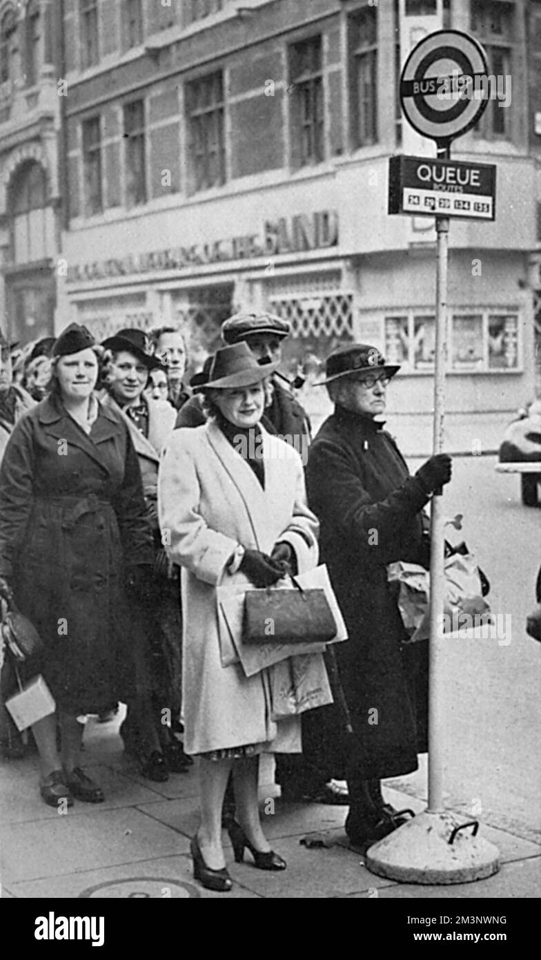 Un panneau d'arrêt de bus mobile sur Tottenham court Road dans le centre de Londres, indiquant clairement où les gens doivent faire la queue pendant les heures de pointe. Date: 1939 Banque D'Images