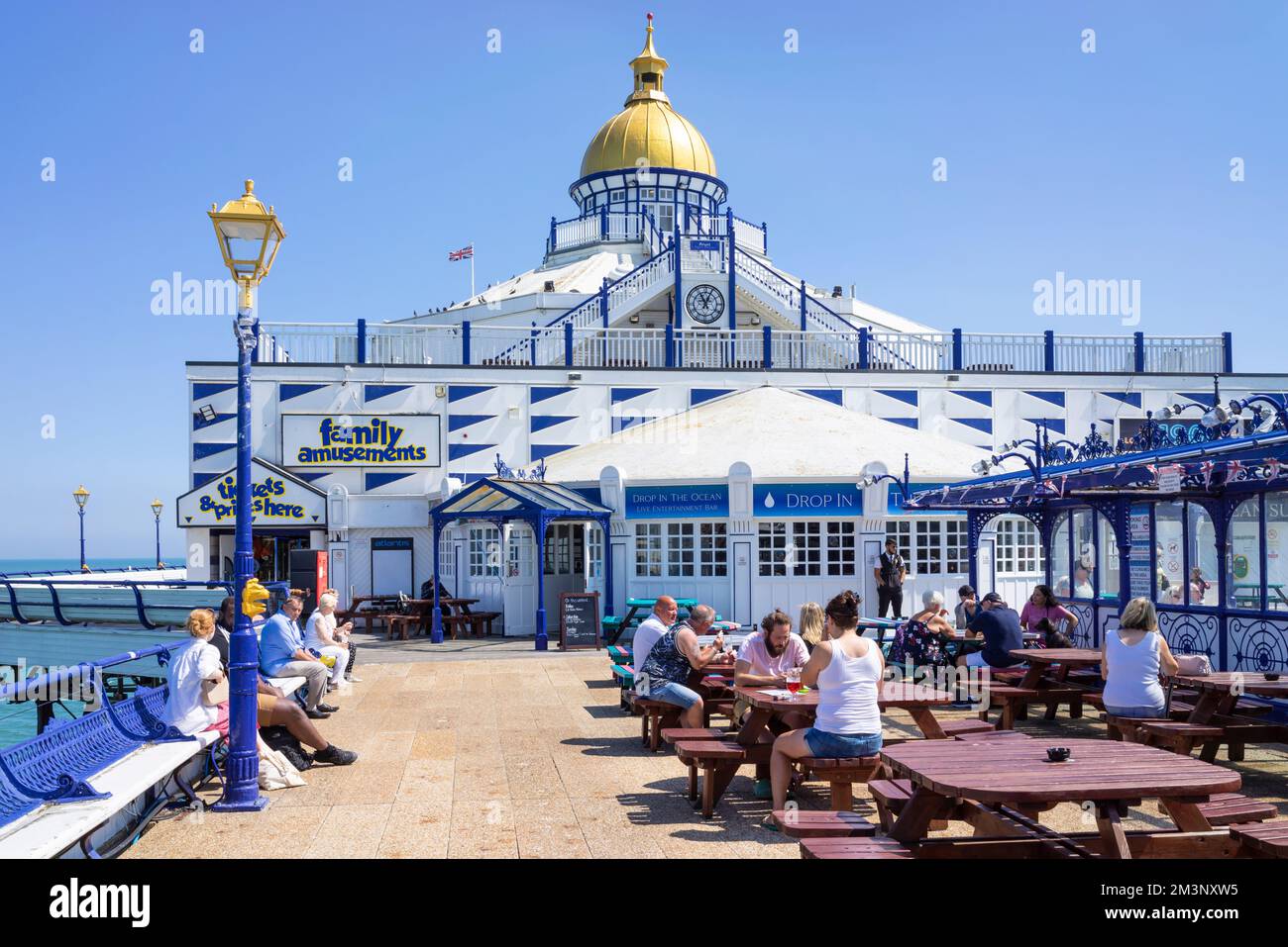 Eastbourne East Sussex les gens se sont assis sur les bancs d'Eastbourne Pier et aux tables de café sur Eastbourne Pier Eastbourne East Sussex England UK GB Europe Banque D'Images