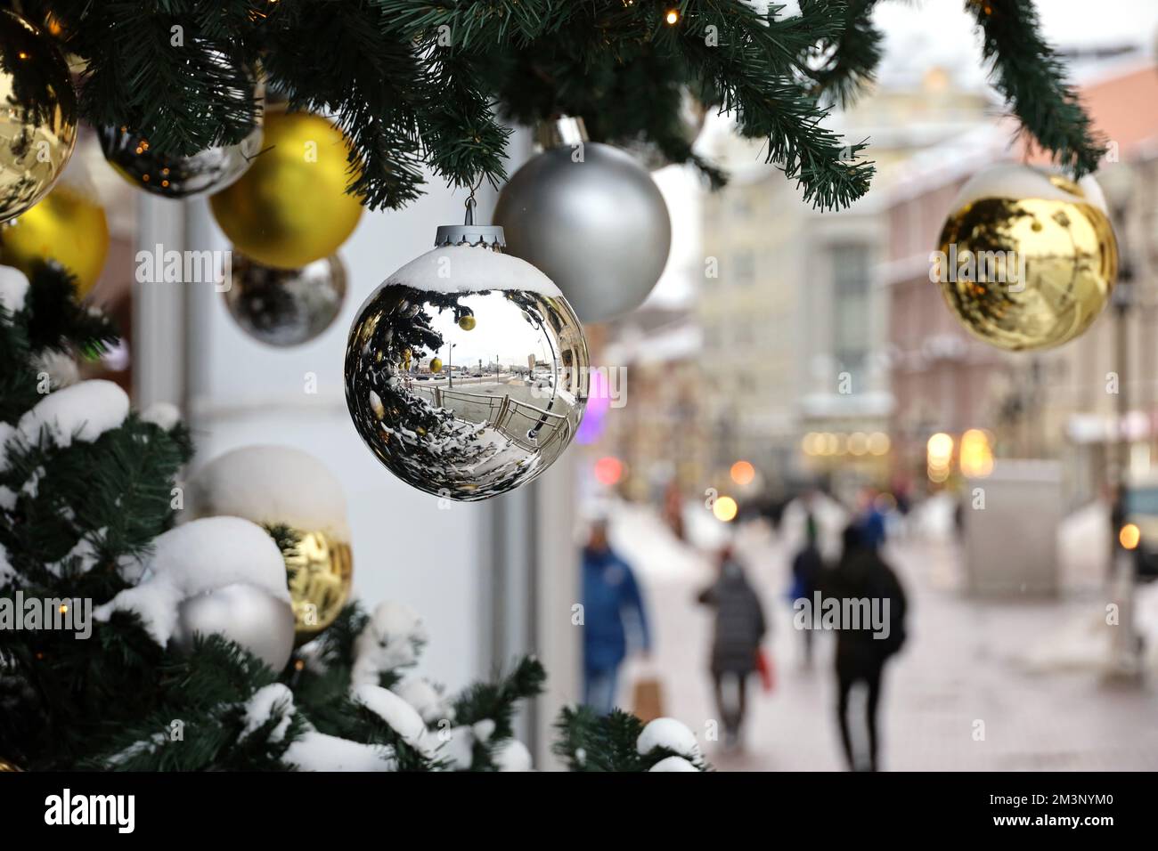 Fête du nouvel an en ville, boules de Noël sur branches de sapin. Décorations de fête dans la rue sur fond de gens, festivités, vacances d'hiver Banque D'Images