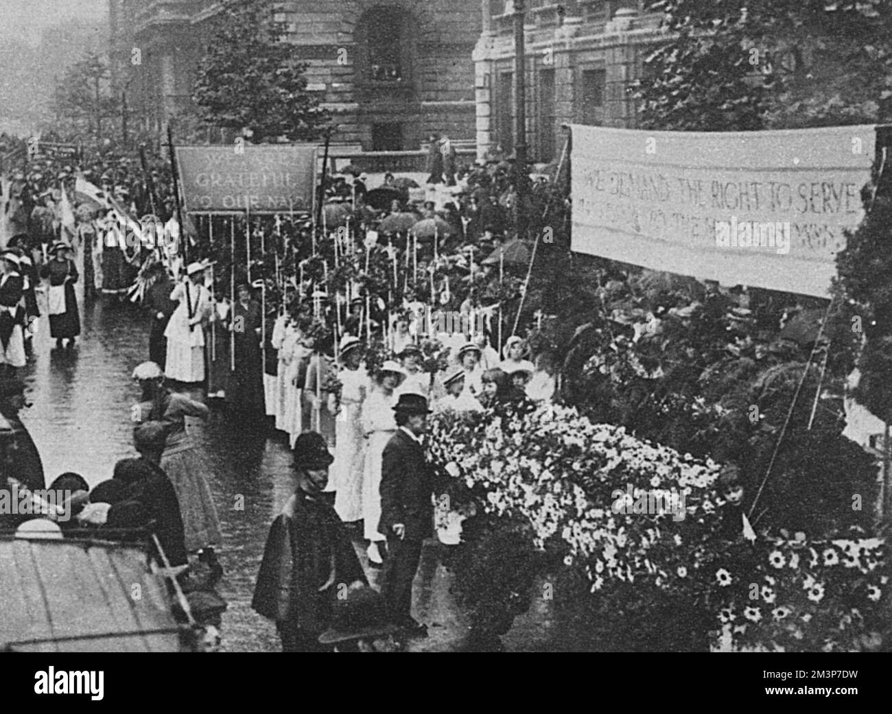 La procession sur le droit de servir des femmes qui passait par Westminster, Londres. La manifestation, qui a eu lieu sur 17 juillet 1915, a été organisée pour exiger que les femmes soient autorisées à partager des munitions et d'autres travaux de guerre.la bannière « la déclaration au ministre des munitions » est représentée ici, avec une exposition florale. Date : 17th juillet 1915 Banque D'Images