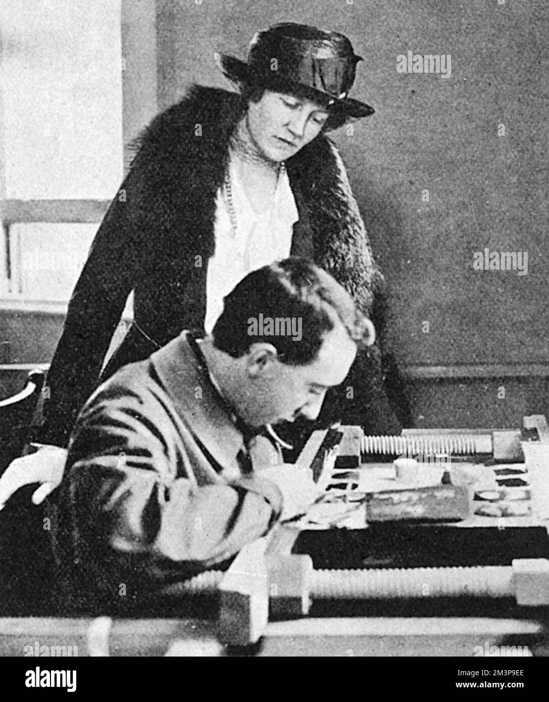 Lady Titchfield, Ivy Cavendish-Bentinck, anciennement Ivy Gordon-Lennox (1887-1982) et plus tard Duchesse de Portland - vu regarder un soldat handicapé au travail à l'école de broderie que la War Services Legion avait établie à Oxford Street pour enseigner aux marins et aux soldats à faire de l'or broderie pour uniforme etc Date: 1918 Banque D'Images