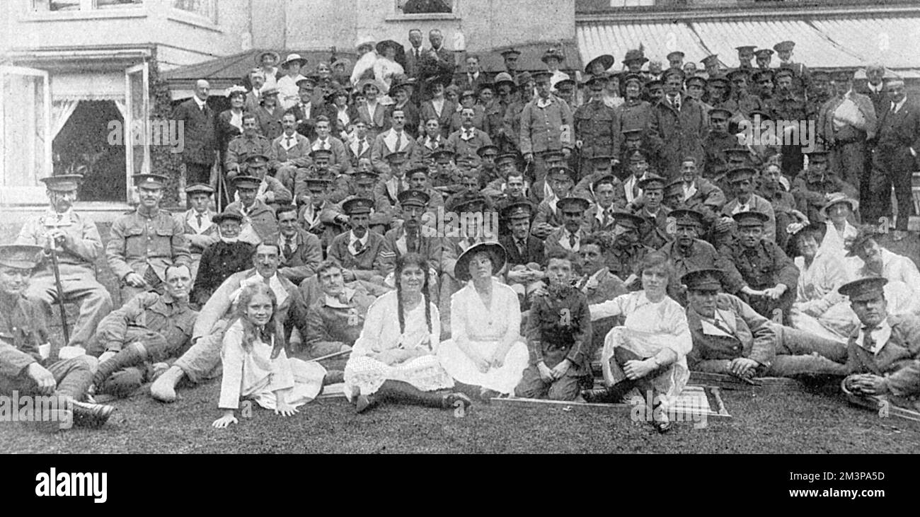 Un groupe a pris à un divertissement donné par Mme George du Cros dans le domaine de sa maison à Frognal Lodge, Hampstead à une centaine de soldats blessés, y compris des Australiens, de divers hôpitaux de Londres. Mme du Cros est assise au centre avec ses quatre enfants - elle a été mariée au capitaine George du Cros et belle-sœur au colonel Arthur du Cros de la compagnie Dunlop Rubber Company. Date: 1915 Banque D'Images