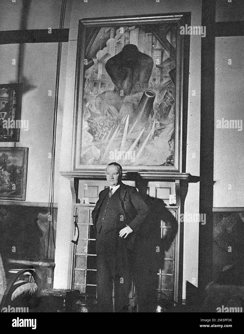 Christopher Richard Wynne Nevinson (1889 - 1946), artiste anglais, debout devant l'une de ses œuvres, intitulée 'homme du XXe siècle'. Nevinson était l'un des plus célèbres artistes de guerre pendant la première Guerre mondiale. Date: 1939 Banque D'Images