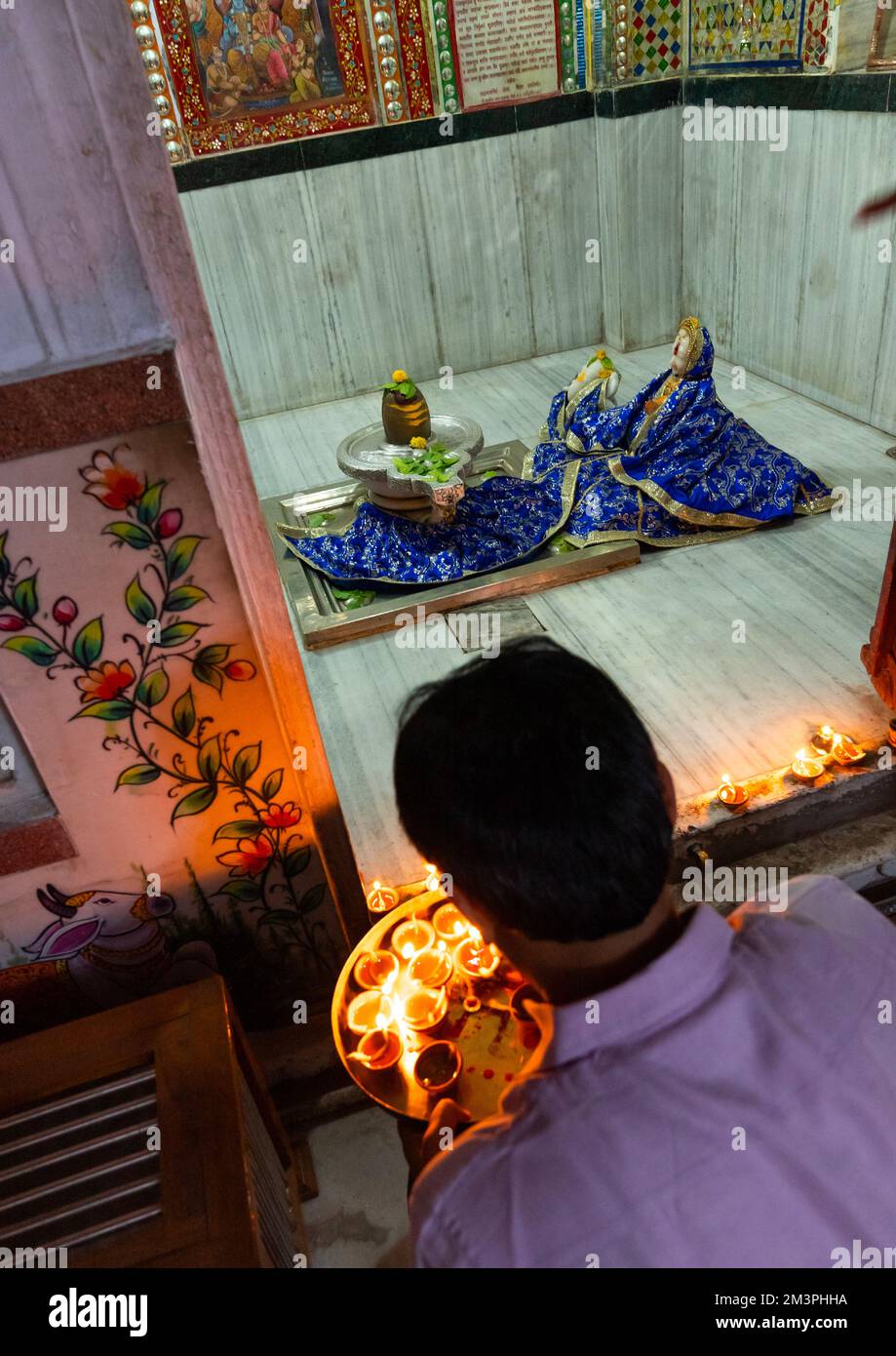 Homme indien offrant des bougies dans un temple pour Diwali, Rajasthan, Jaipur, Inde Banque D'Images