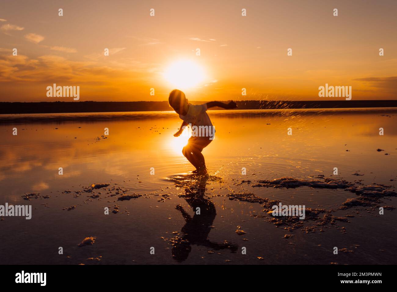 Silhouette d'enfant masculin dans les rayons du soleil. Air frais, environnement concept. Banque D'Images