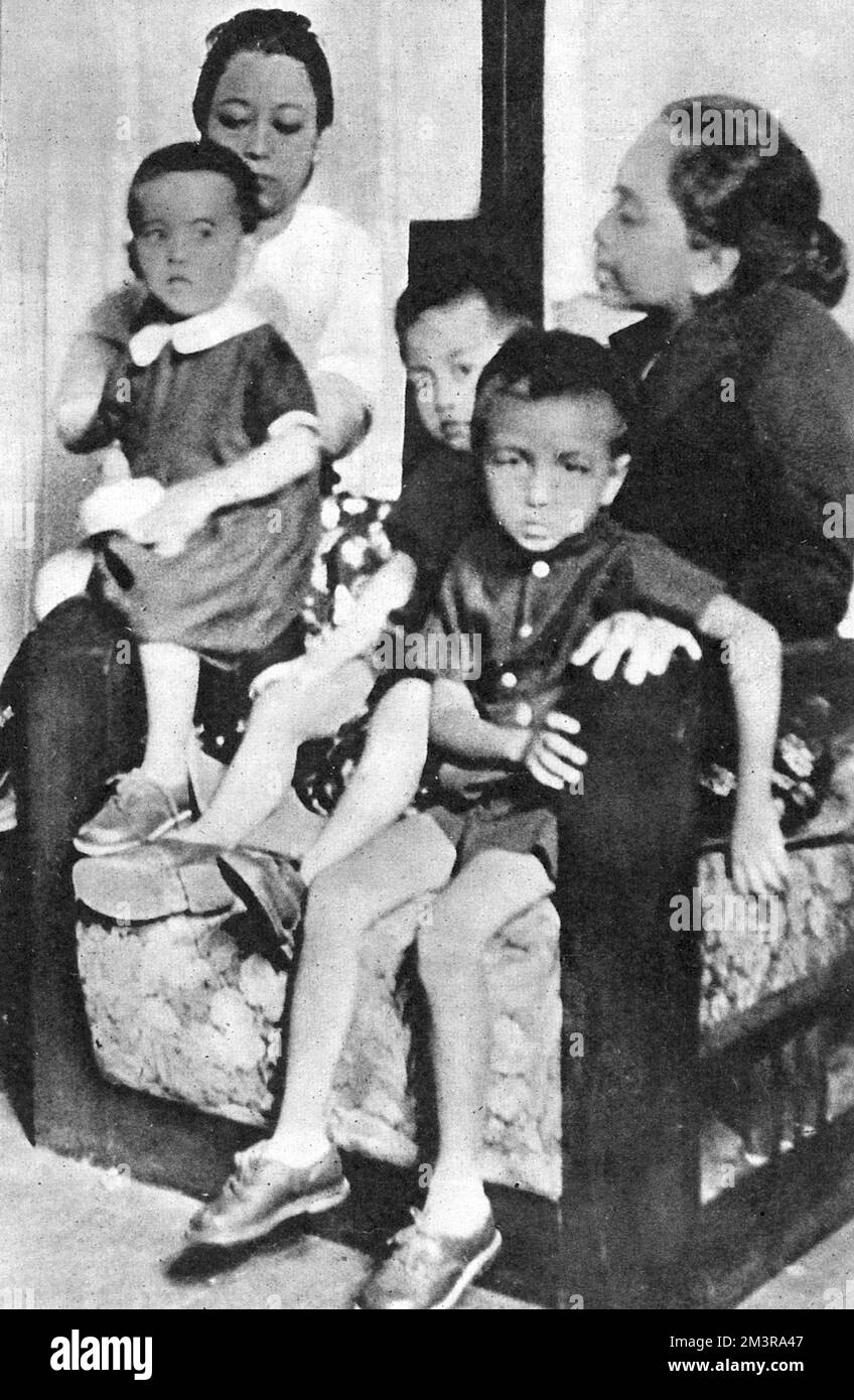 Aung San Suu Kyi, 2 ans (1945- ), homme politique de l'opposition birmane et présidente de la Ligue nationale pour la démocratie (NLD) en Birmanie - photo à l'époque des funérailles de son Père général U Aung San, assassiné le 19th juillet 1947. Aung San Suu Kyi est photographiée (à gauche) avec ses deux frères et sa mère (à droite - en noir). Prix Nobel de la paix en 199. Date: 1947 Banque D'Images