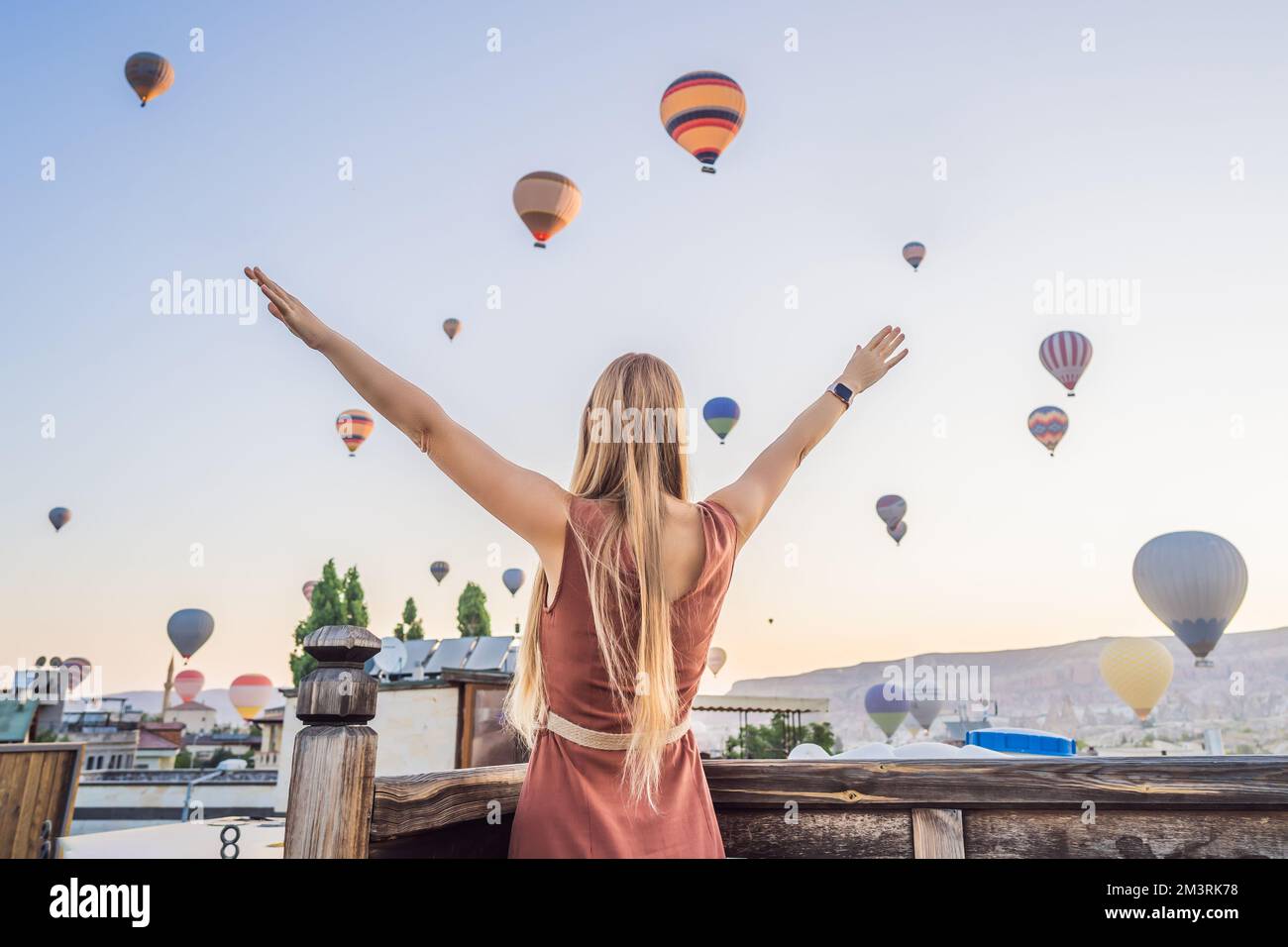 Femme touristique regardant des ballons d'air chaud en Cappadoce, Turquie. Happy Travel en Turquie concept. Femme sur un sommet de montagne jouissant d'une vue magnifique Banque D'Images