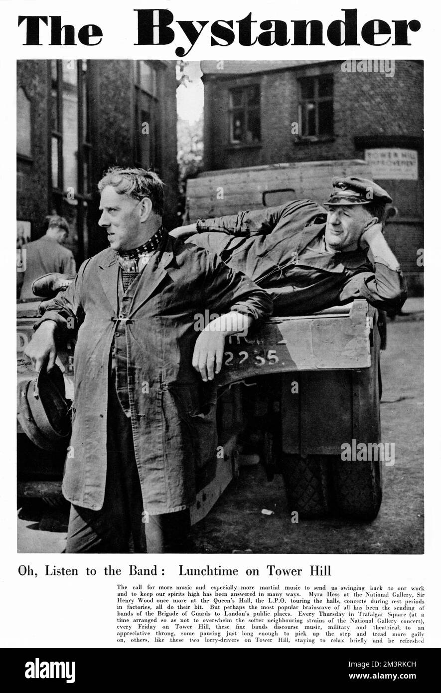 La couverture du magazine Bystander présente deux pilotes de camion à Tower Hill, Londres, qui ont profité d'une représentation du groupe Brigade of the Guards lors de leur pause déjeuner. 1940 Banque D'Images