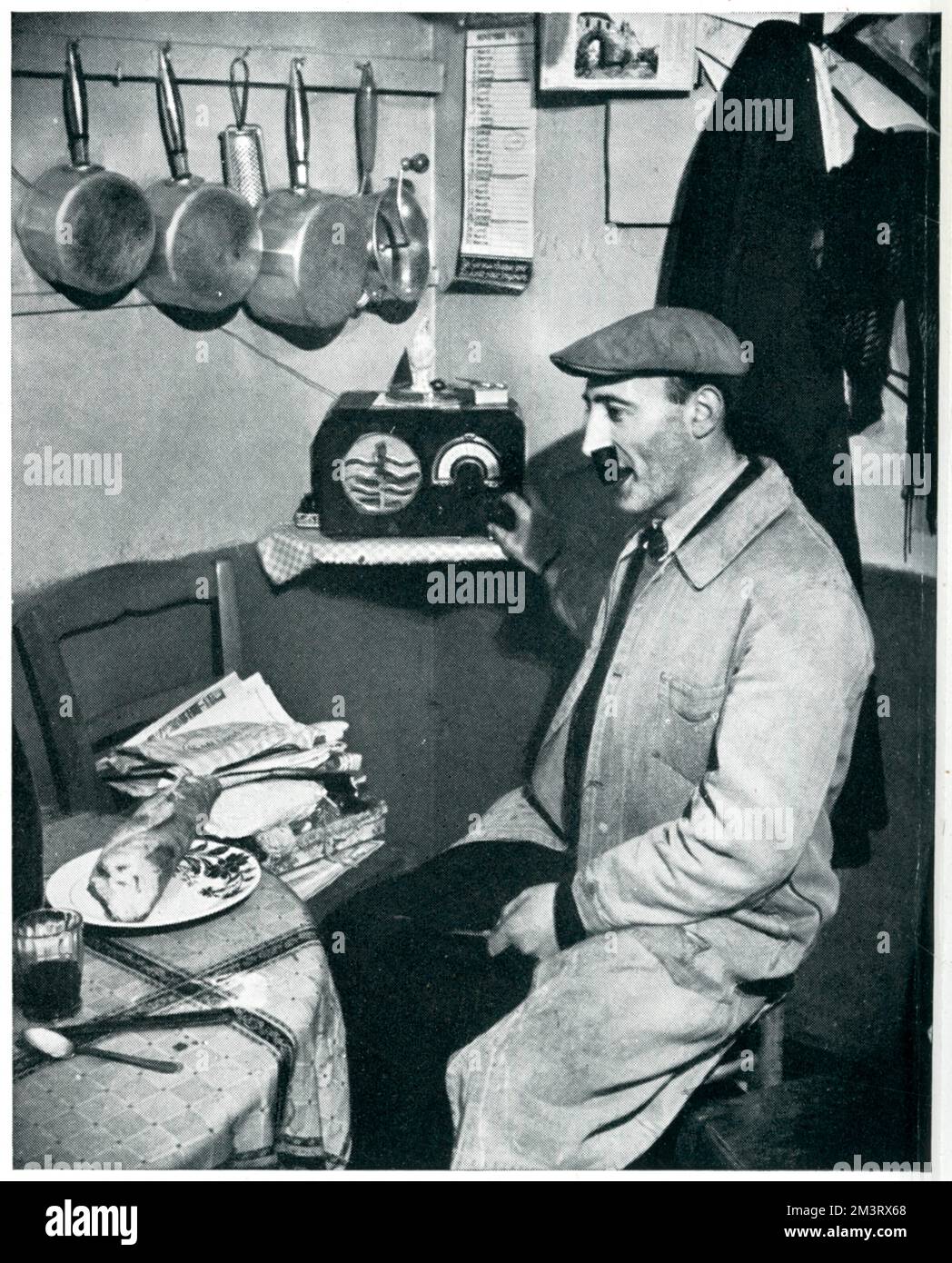 Septembre 1939. Un greengrocer de Montmartre à Paris profite d'un souper tranquille derrière son magasin et allume la radio pour écouter les nouvelles. Date: 1939 Banque D'Images